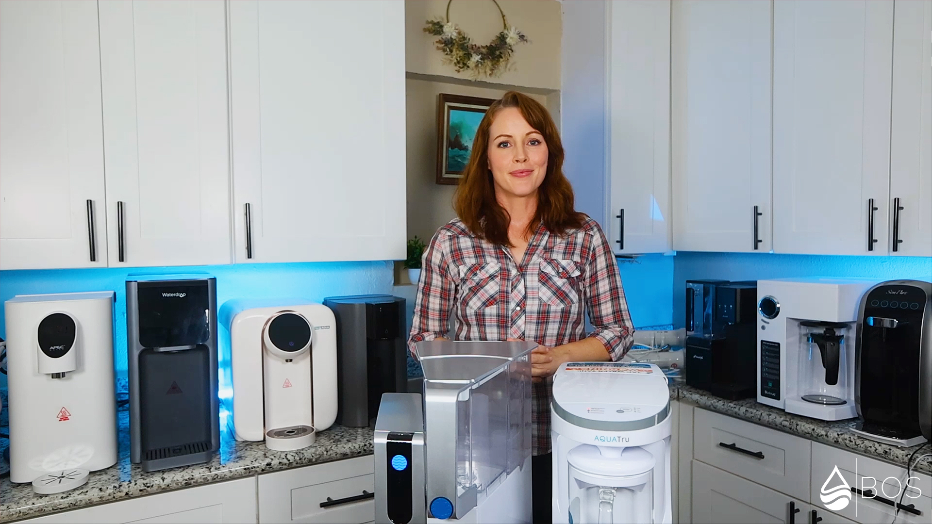 Sara in Her Kitchen Surrounded by Countertop RO Systems