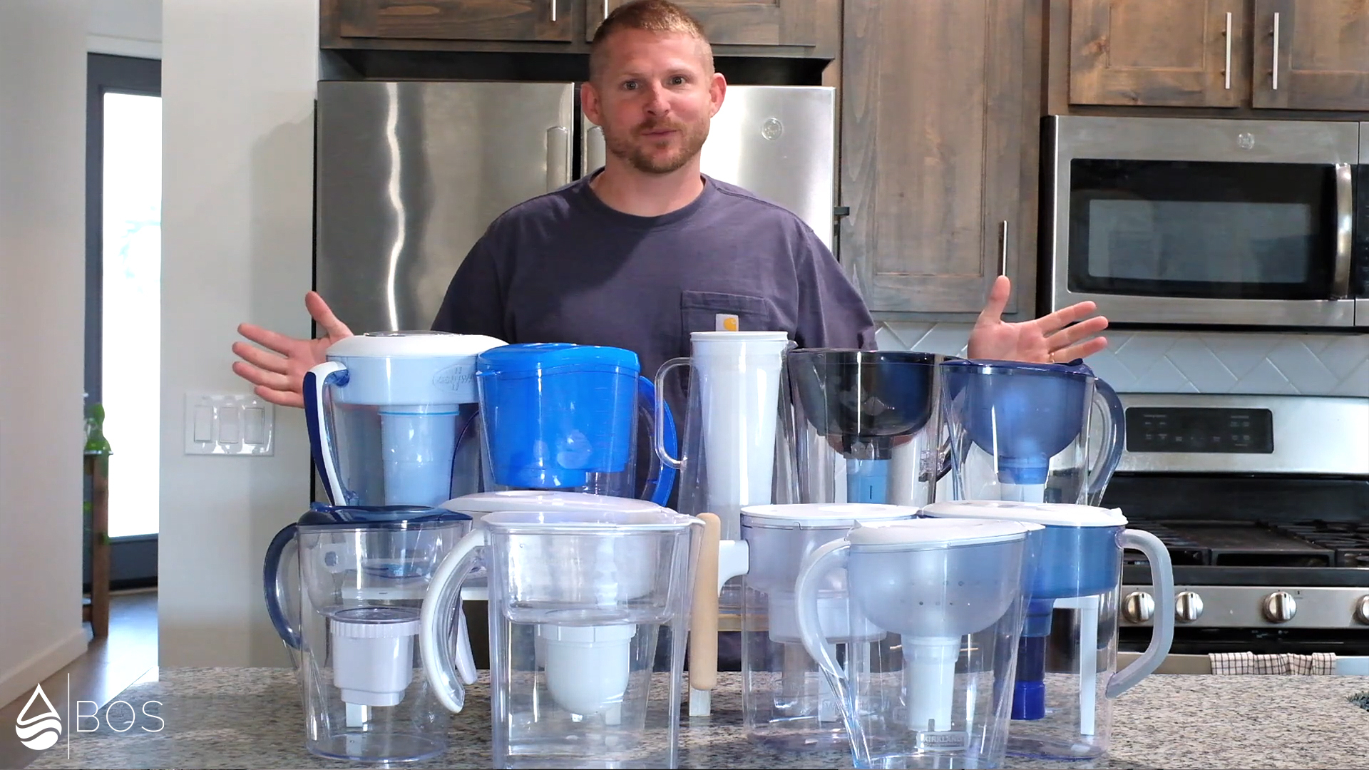 Mike in His Kitchen With a Bunch of Water Filter Pitchers in Front of Him